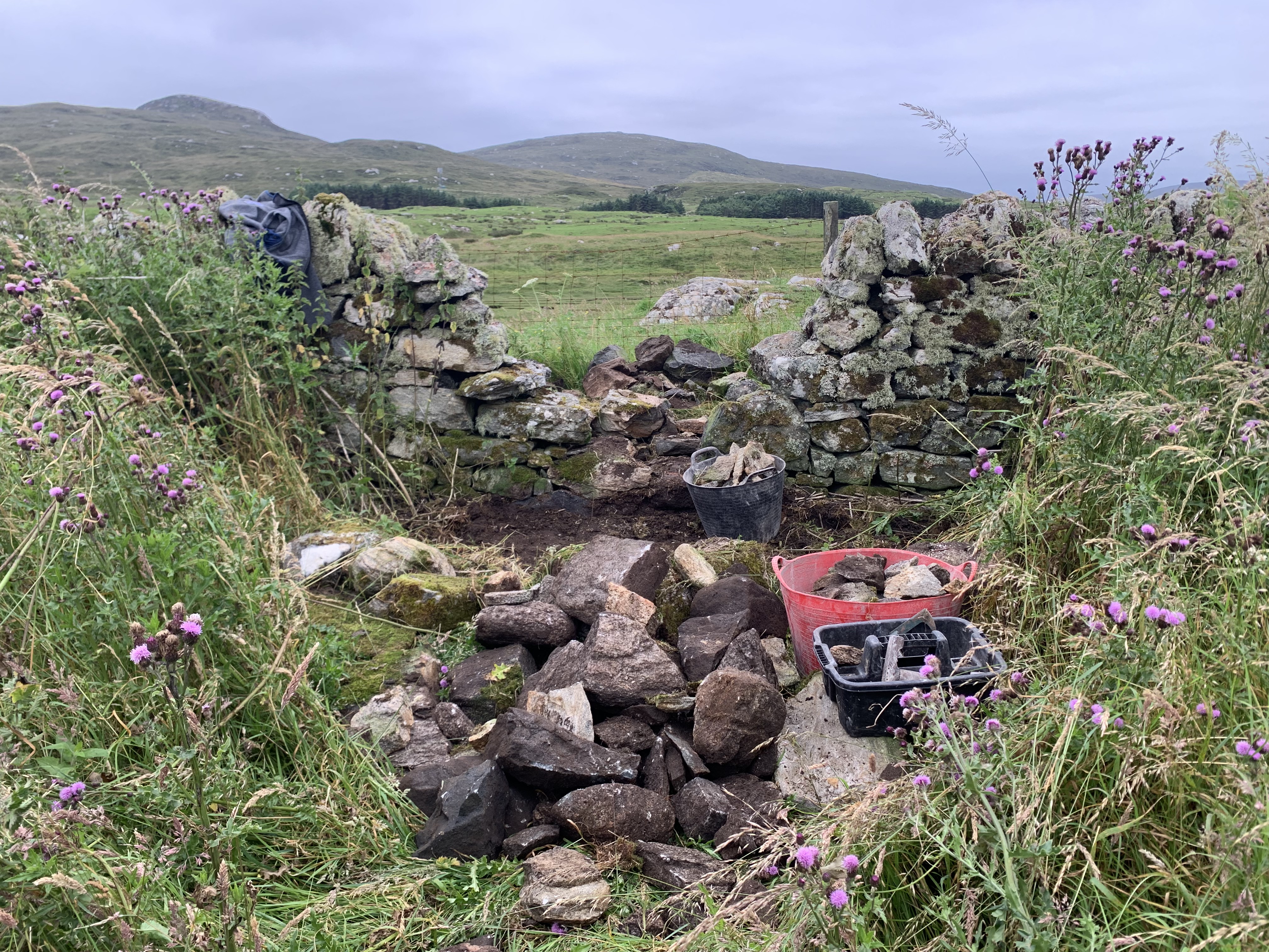 Stripped out section of dry stone wall with the collapsed stone in the foreground
